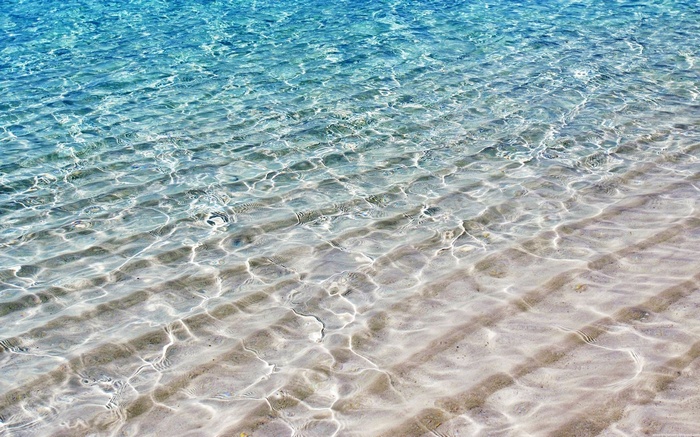 Clear blue water over sandy beach