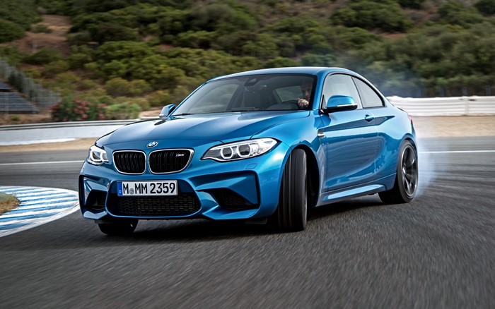 Blue BMW M2 car drifting on a race track