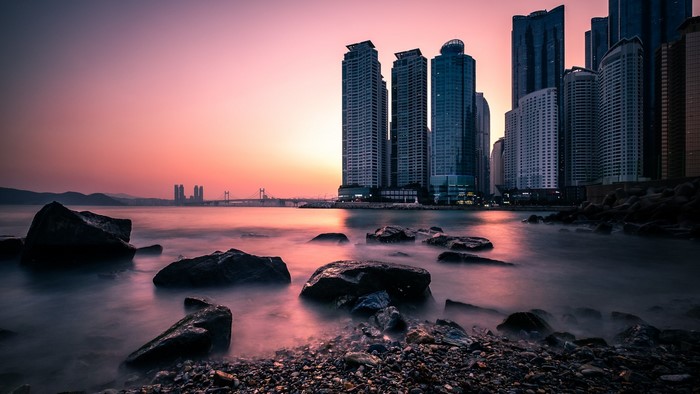 Cityscape with skyscrapers and bridge at sunset