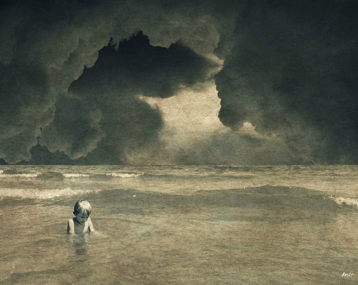 Child in the sea under dark clouds