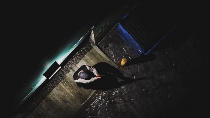 Person holding a phone in a dark, wet environment