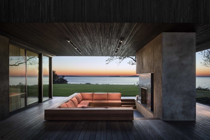 Modern outdoor living room with fireplace at sunset