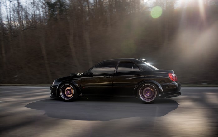 Black Subaru WRX STI Impreza on a road