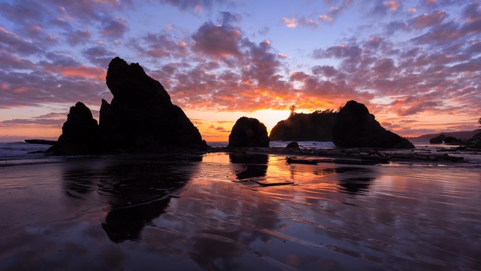 Sunset over rocky beach with colorful clouds