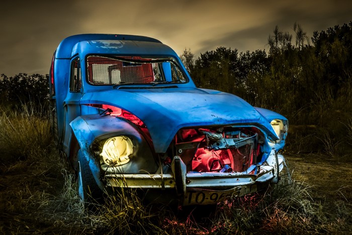 Abandoned blue car at night