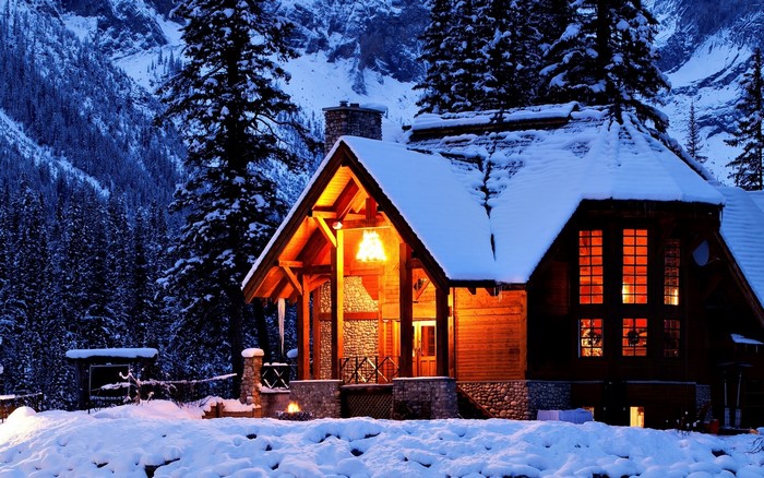 Wooden cabin in a snowy forest at dusk