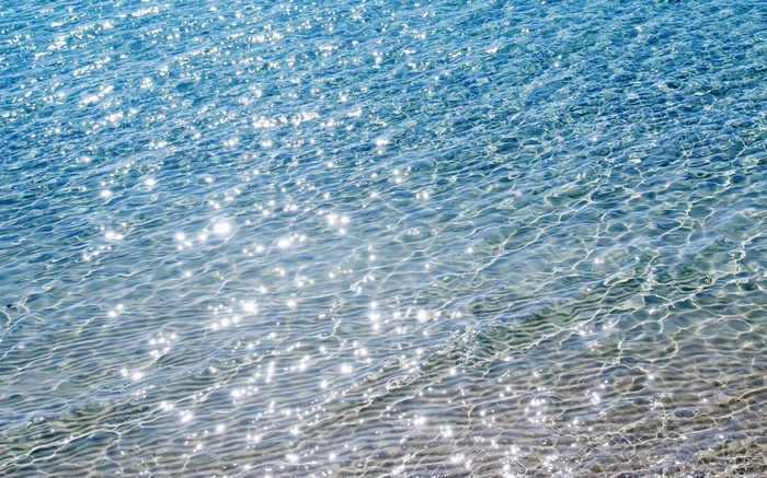 Sunlight sparkling on clear blue ocean water