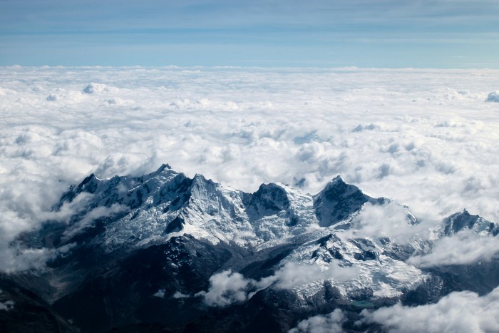 Snow-capped Andes mountains above clouds in Peru