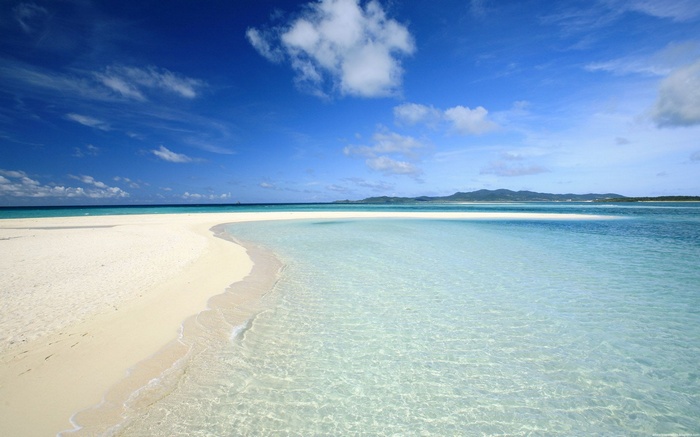 White sand beach and clear turquoise water under blue sky