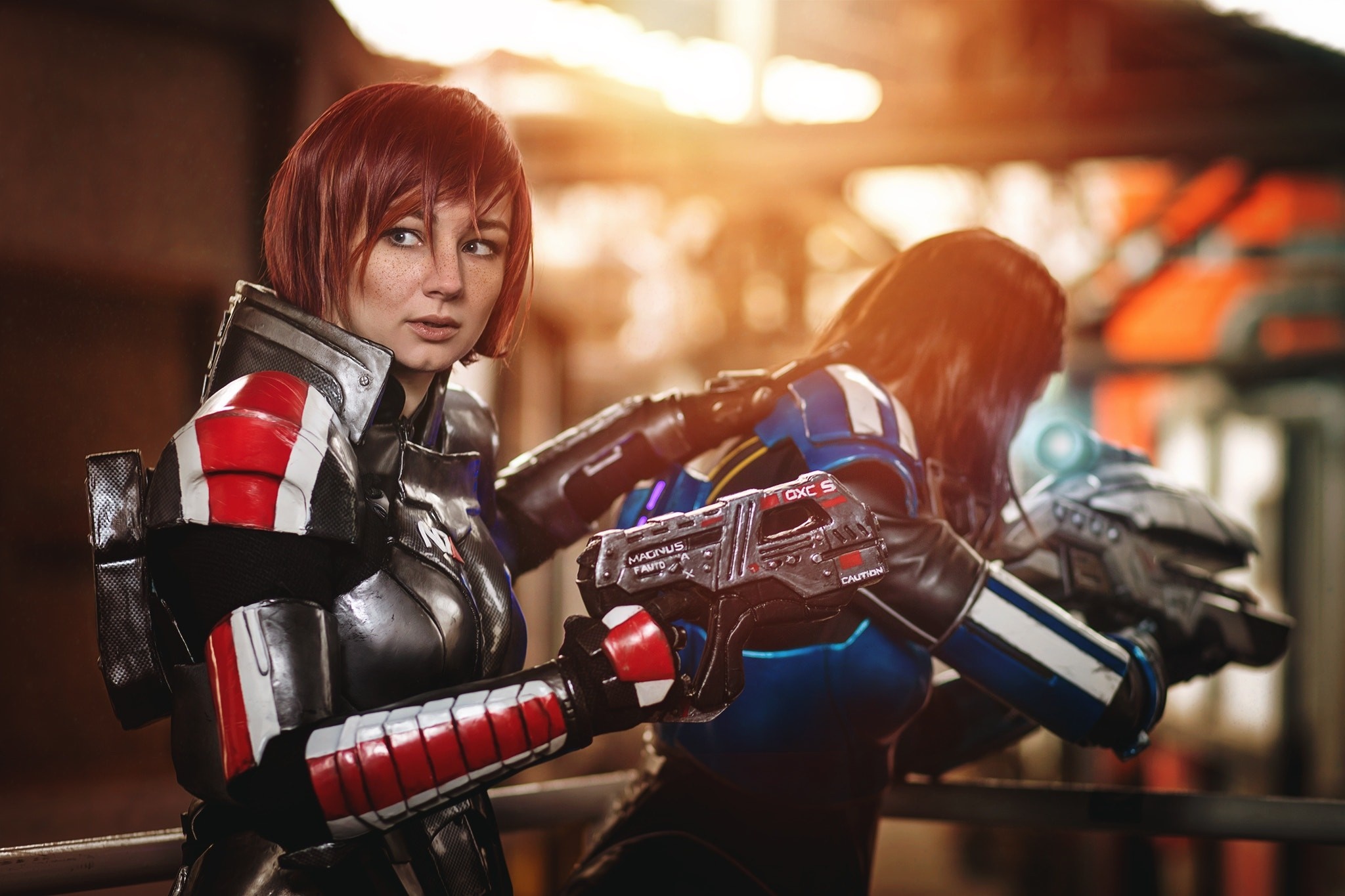 Two women in Mass Effect cosplay with guns HD Wallpaper