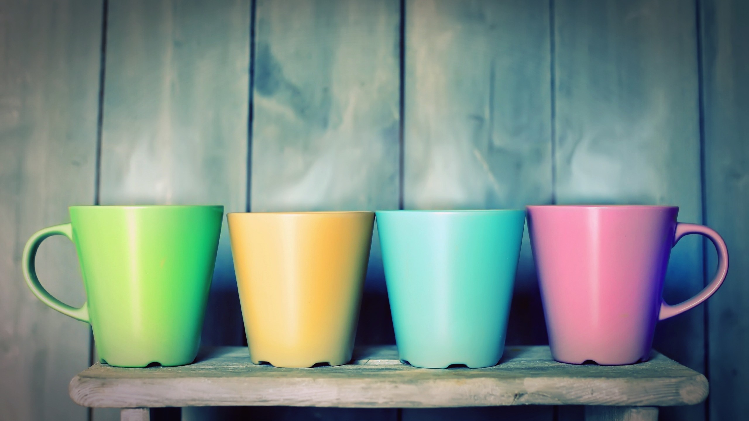 Four colorful mugs on a wooden shelf HD Wallpaper