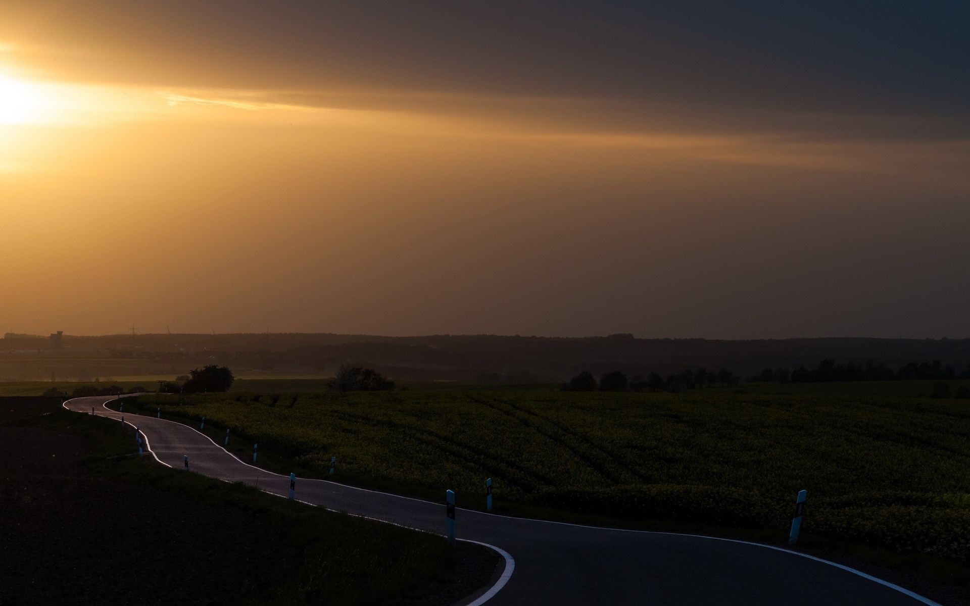 Winding road through fields at sunset HD Wallpaper