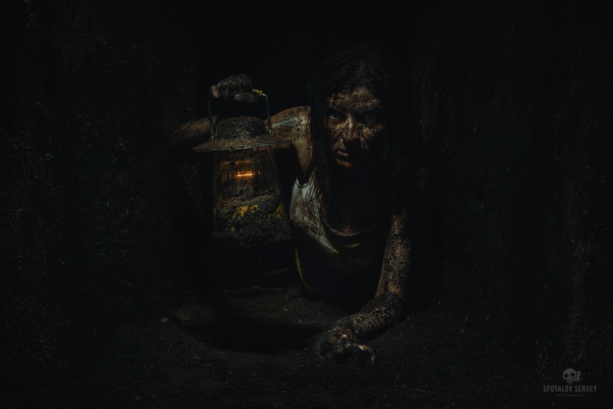 Woman covered in dirt holding a lantern in darkness HD Wallpaper
