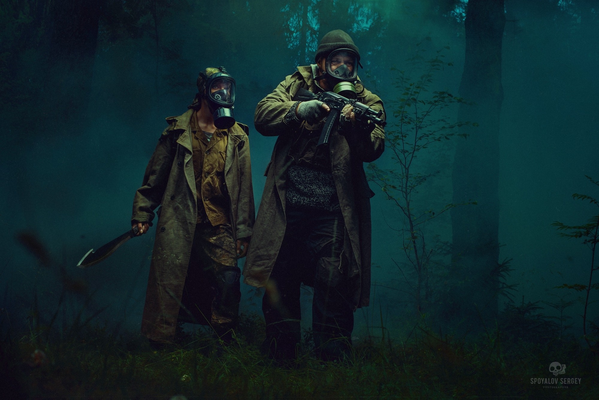 Two men in gas masks in a dark forest with weapons HD Wallpaper