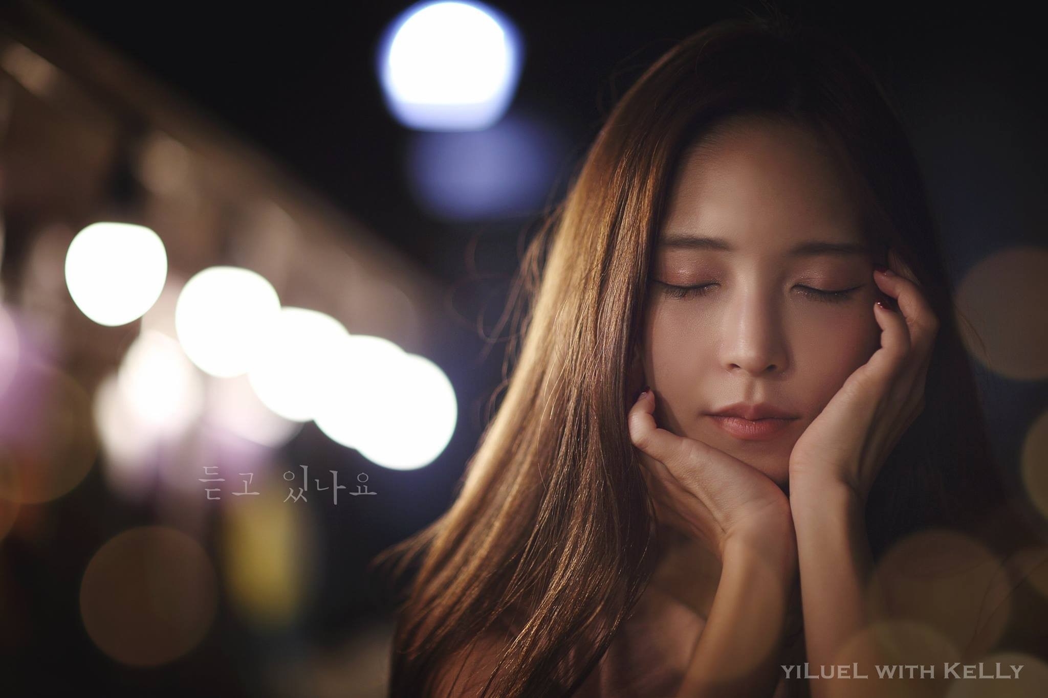Woman with eyes closed in bokeh lighting HD Wallpaper