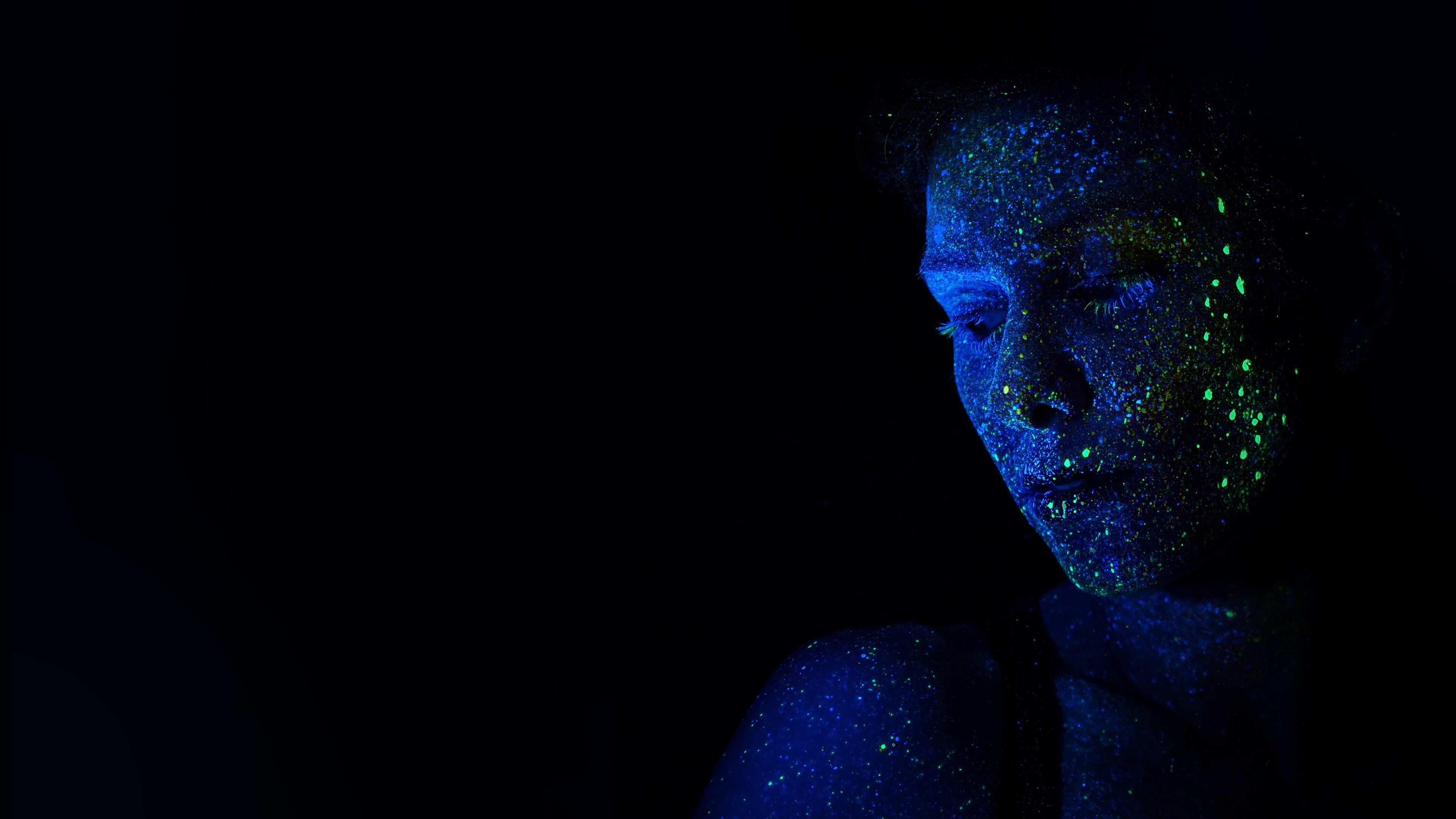 Person with glowing blue and green paint under blacklight HD Wallpaper