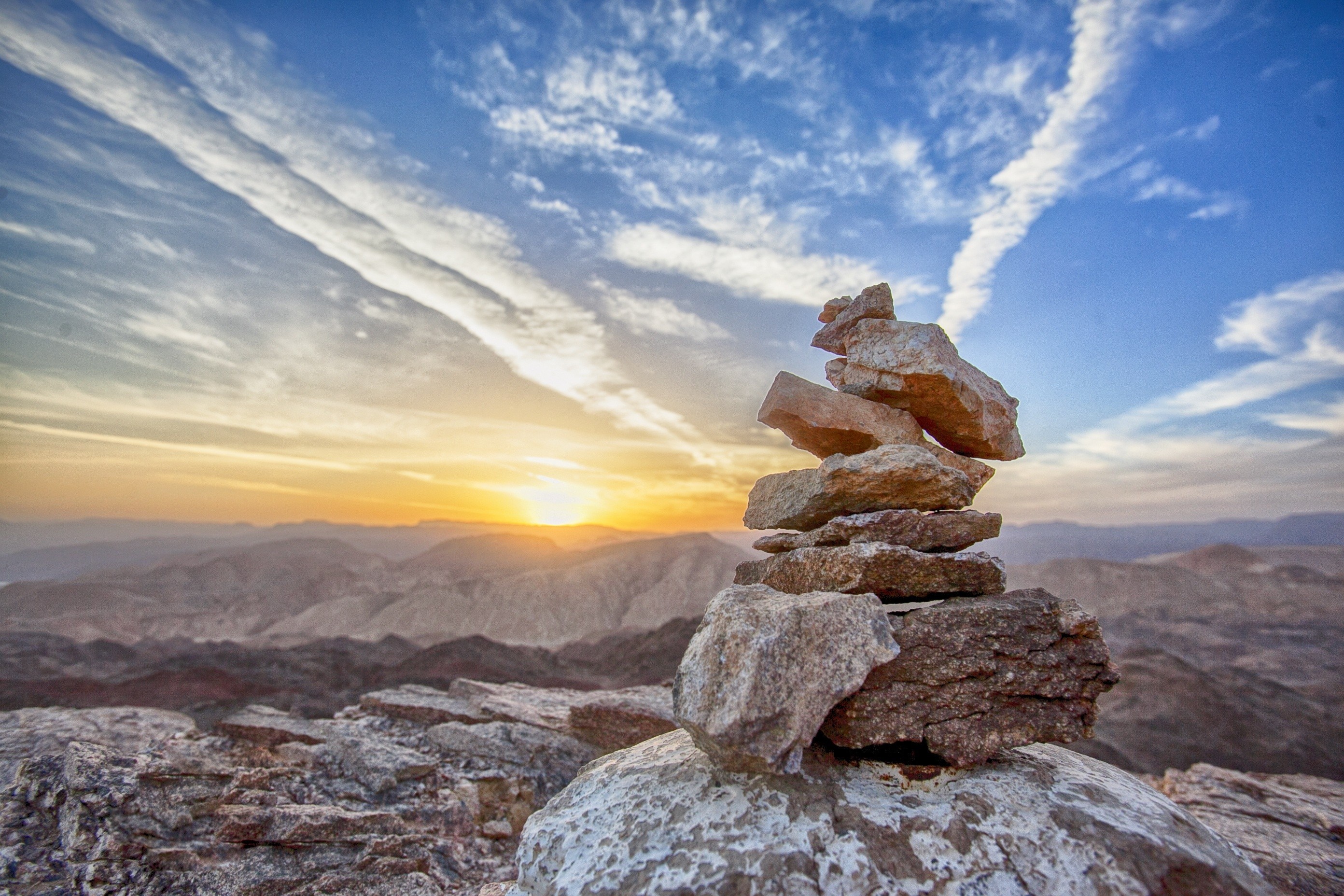 Stacked rocks on a mountain summit at sunrise HD Wallpaper