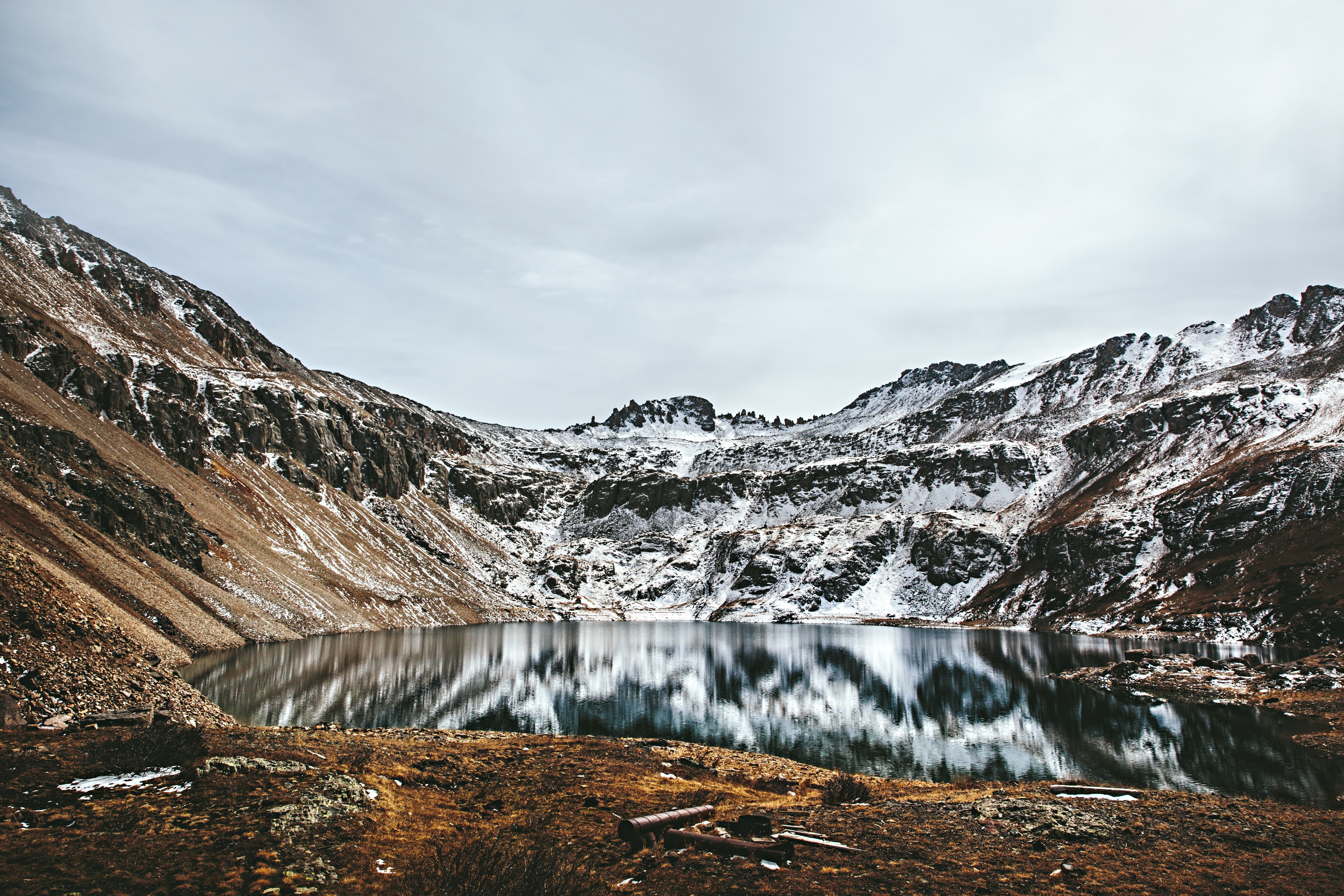 Snow-capped mountains reflected in a calm lake HD Wallpaper