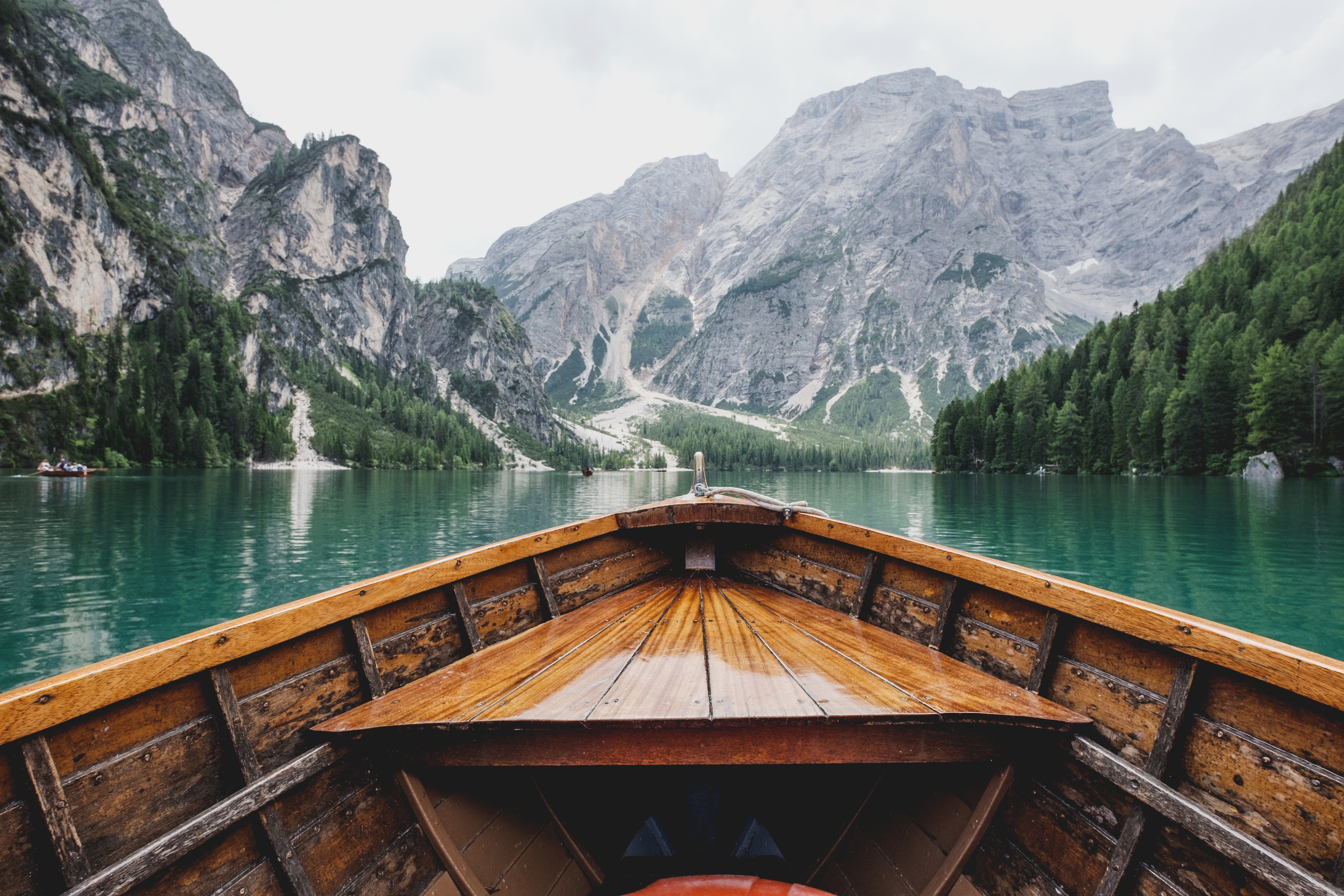 Wooden boat on a turquoise lake with mountains HD Wallpaper