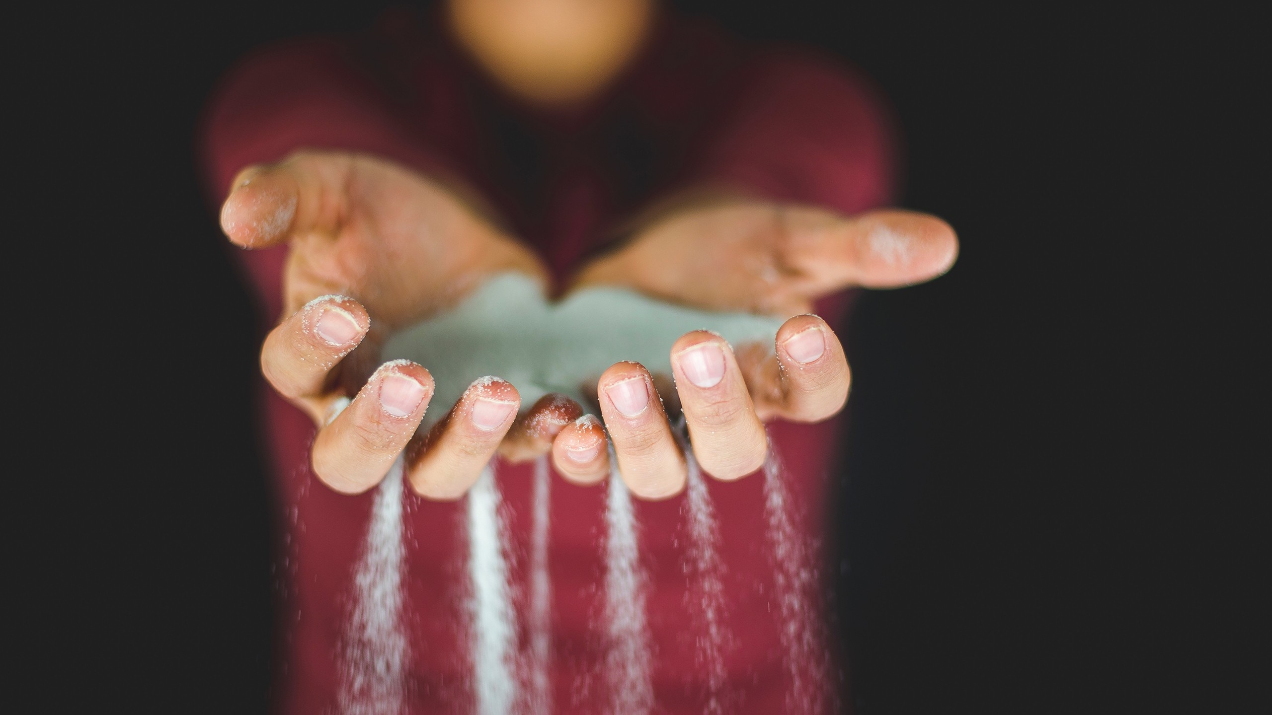 Hands letting sand fall through fingers HD Wallpaper