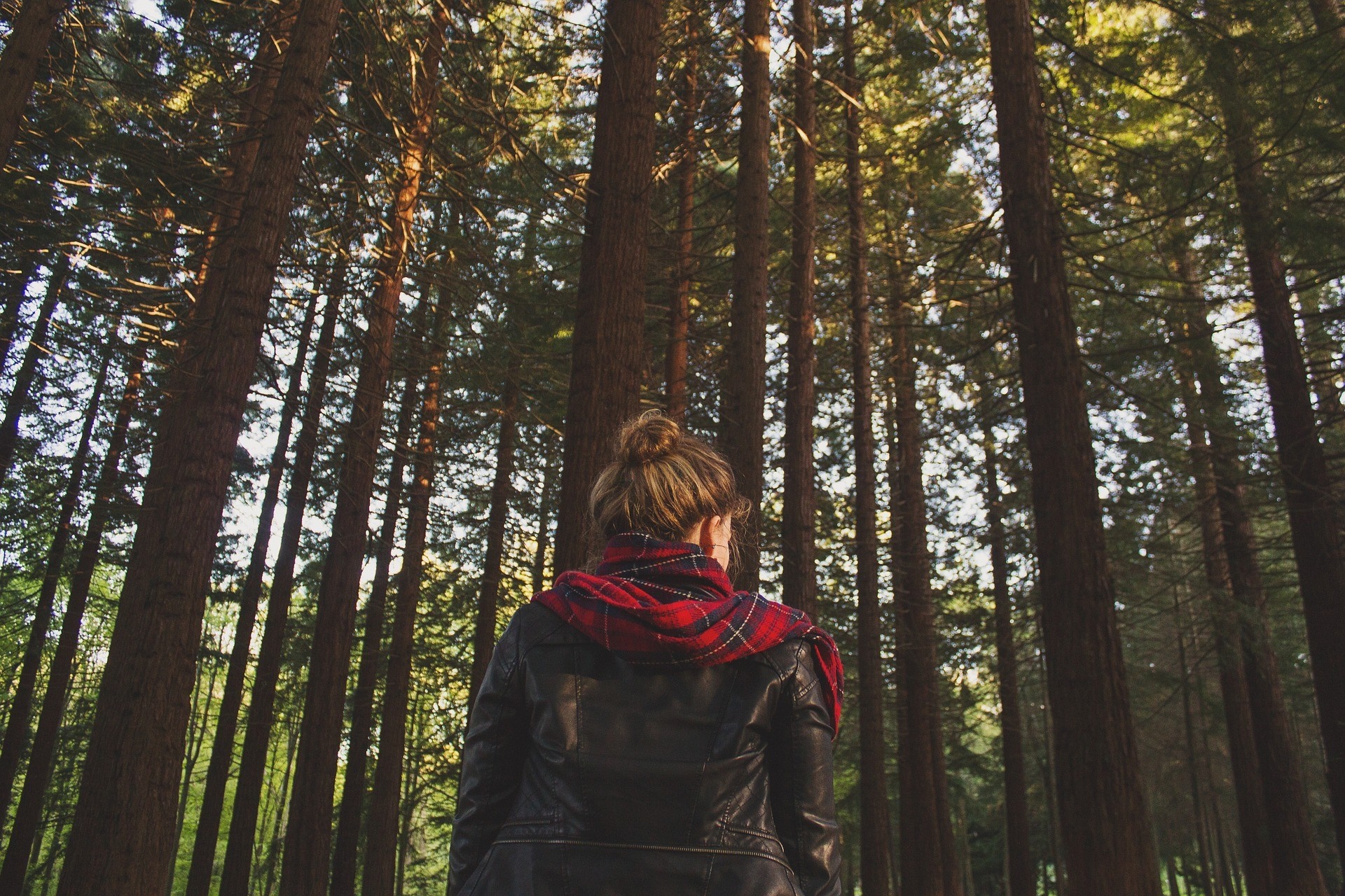 Woman in leather jacket and scarf in a forest HD Wallpaper