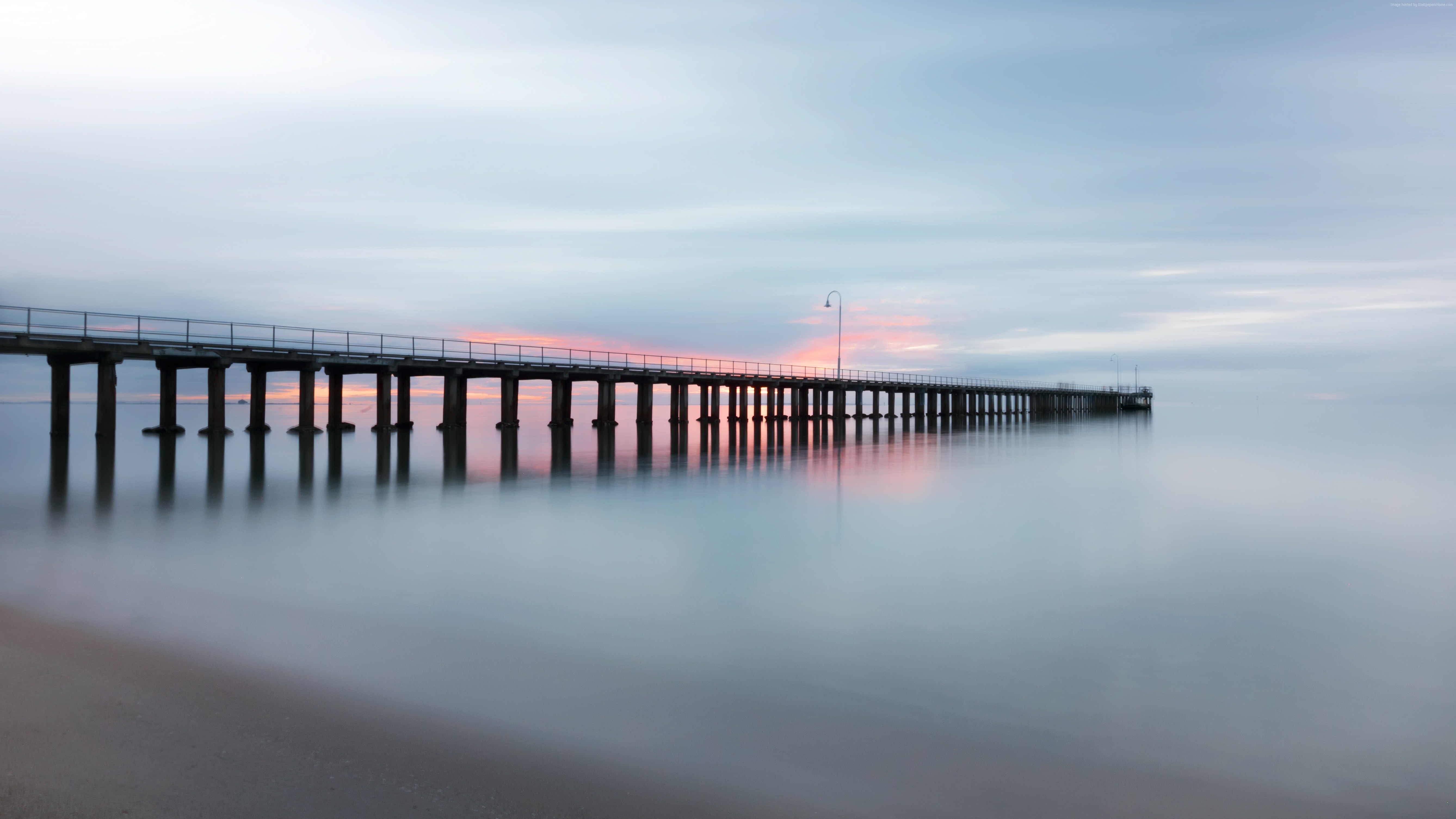 Long pier over calm ocean at sunset HD Wallpaper