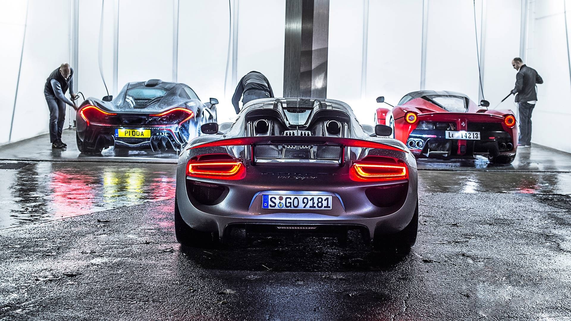 Three supercars being washed by men HD Wallpaper