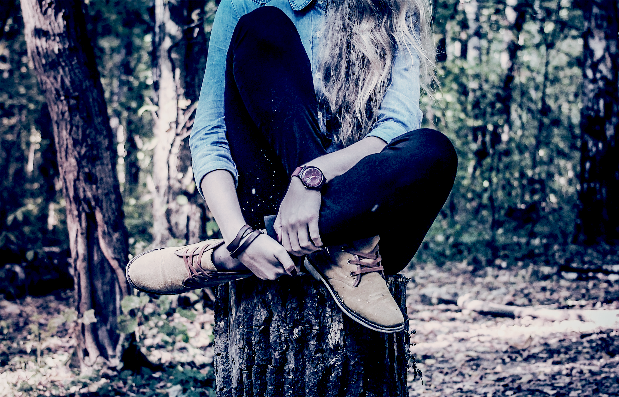 Woman sitting on a tree stump in a forest HD Wallpaper