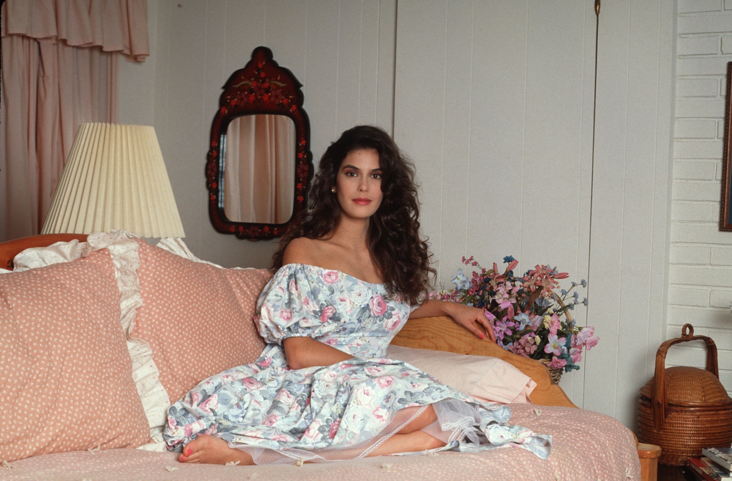 Teri Hatcher in a floral dress sitting on a bed HD Wallpaper