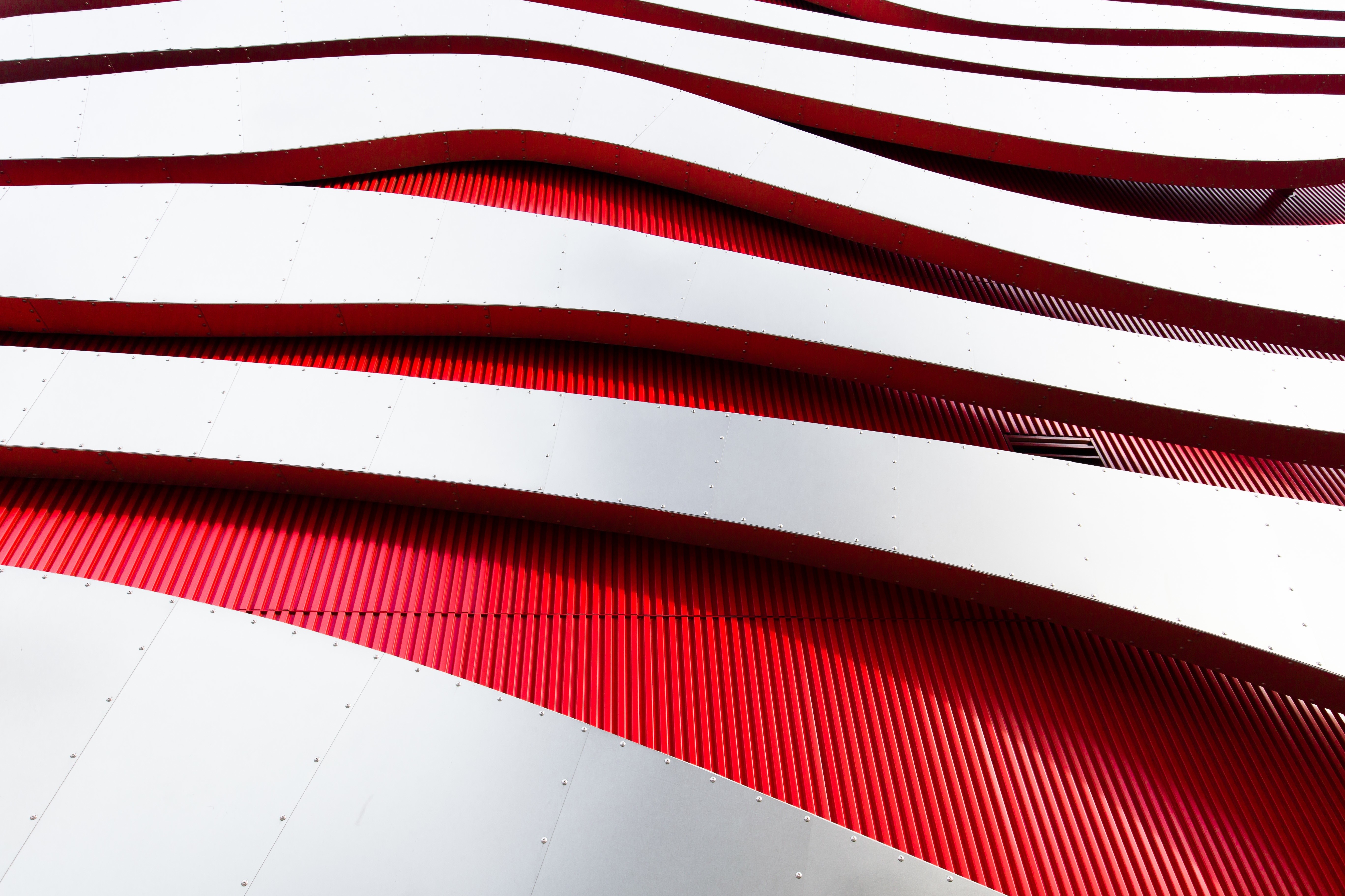 Modern architecture with red and white wavy facade HD Wallpaper