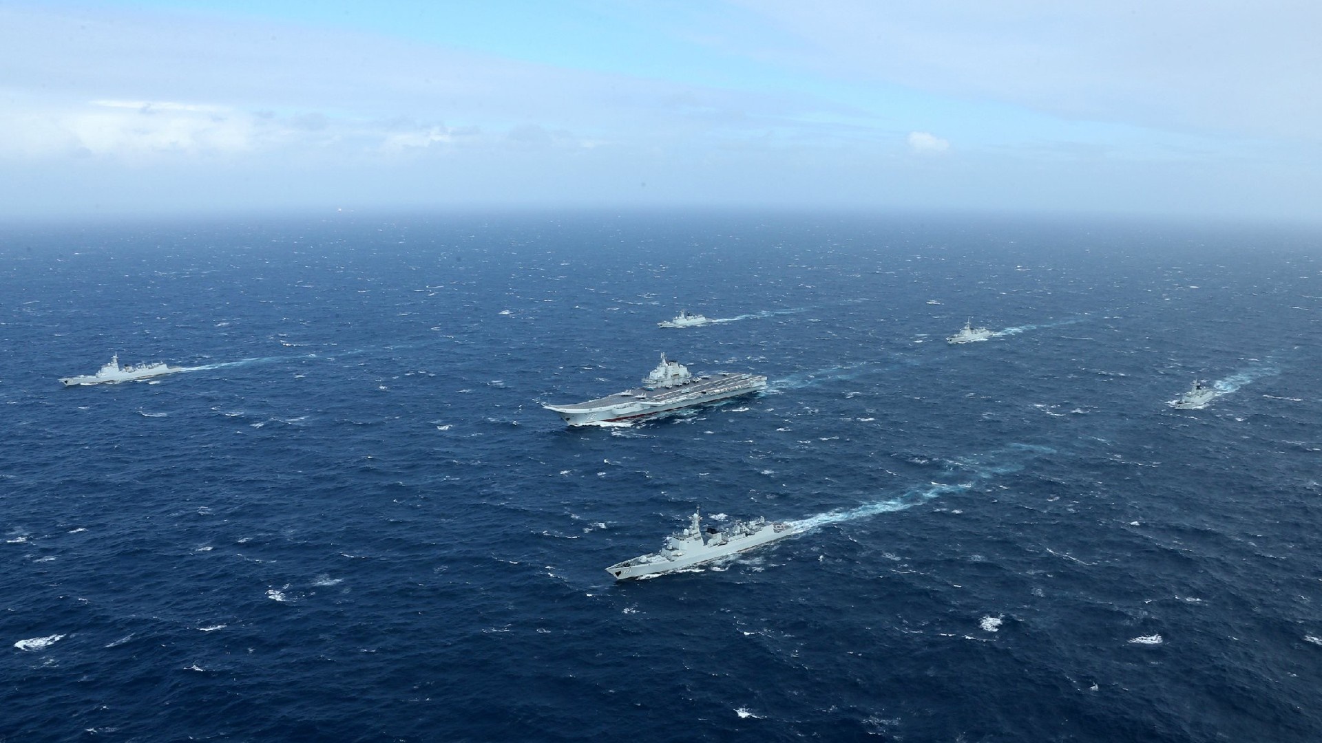 Aircraft carrier and escort ships at sea HD Wallpaper