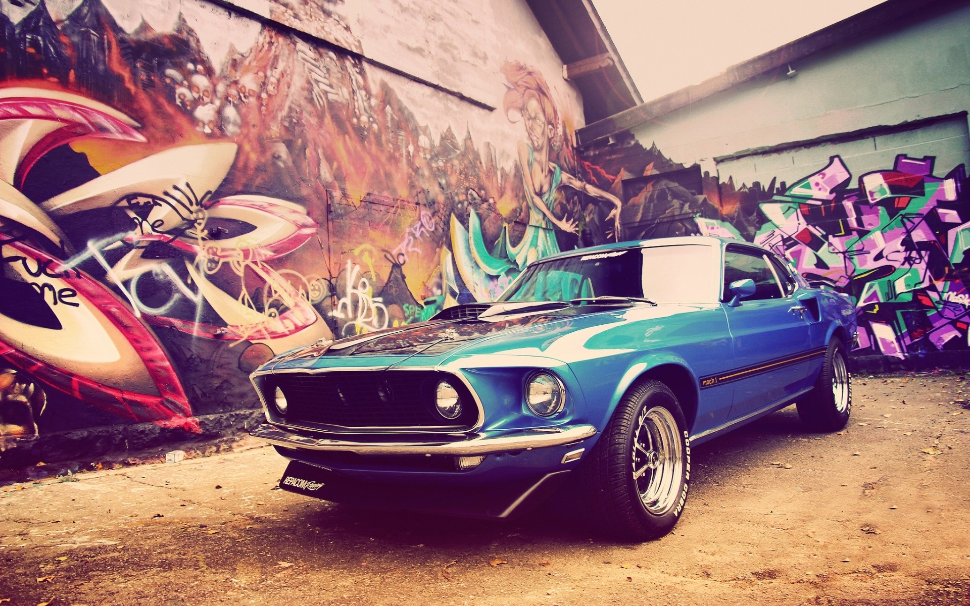 Blue Ford Mustang parked in front of graffiti wall HD Wallpaper
