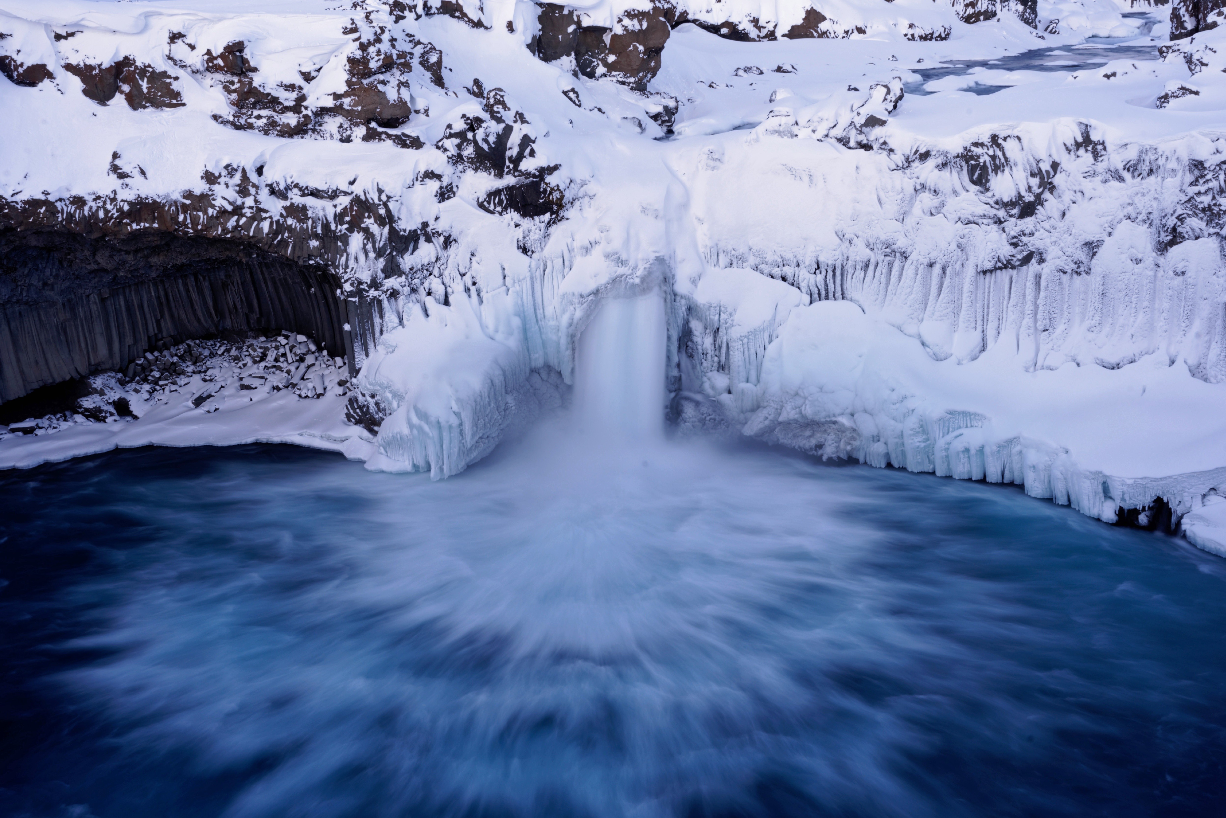 Frozen waterfall with basalt columns and icy water HD Wallpaper