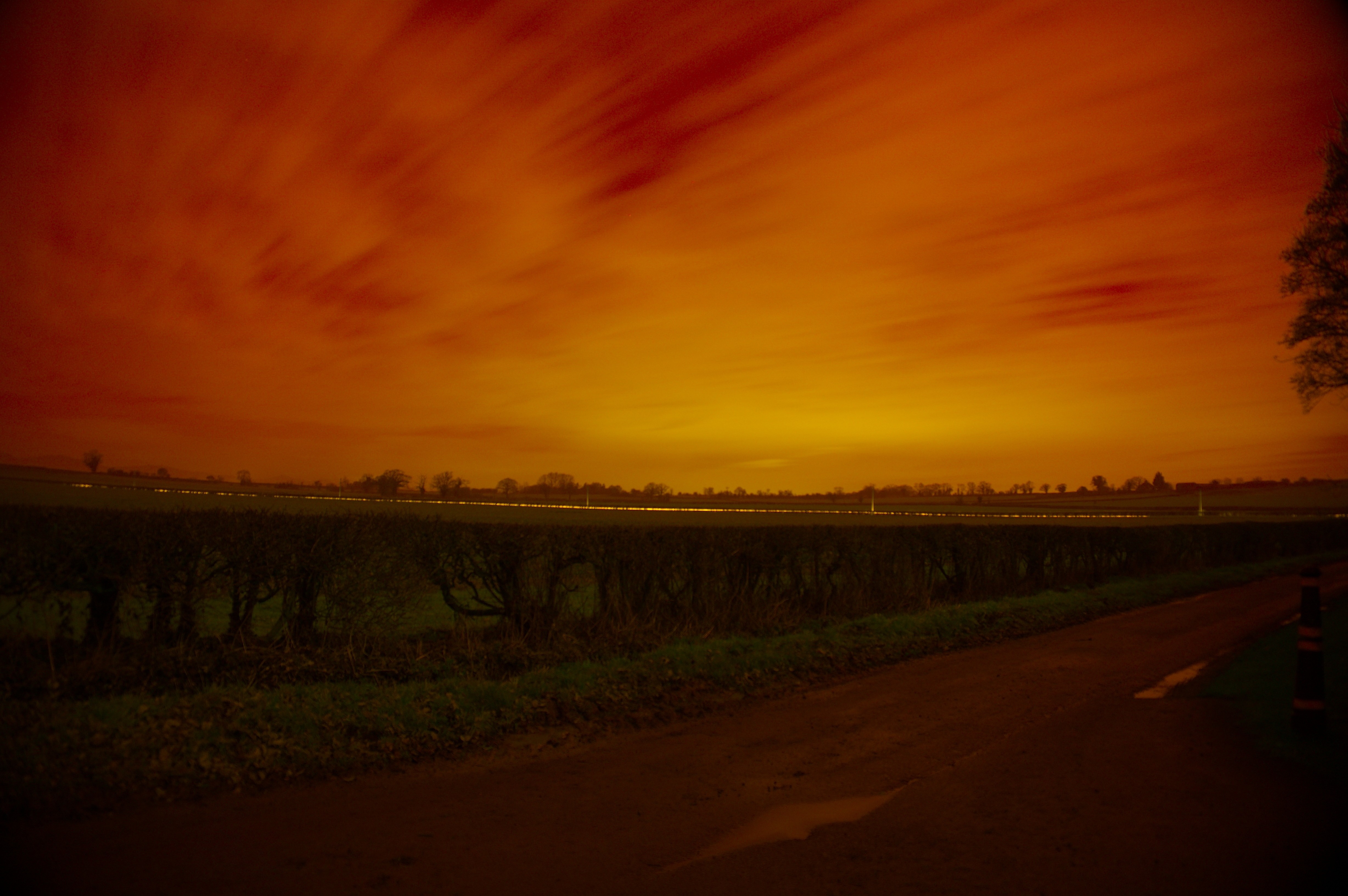 Orange sky over a field and road HD Wallpaper