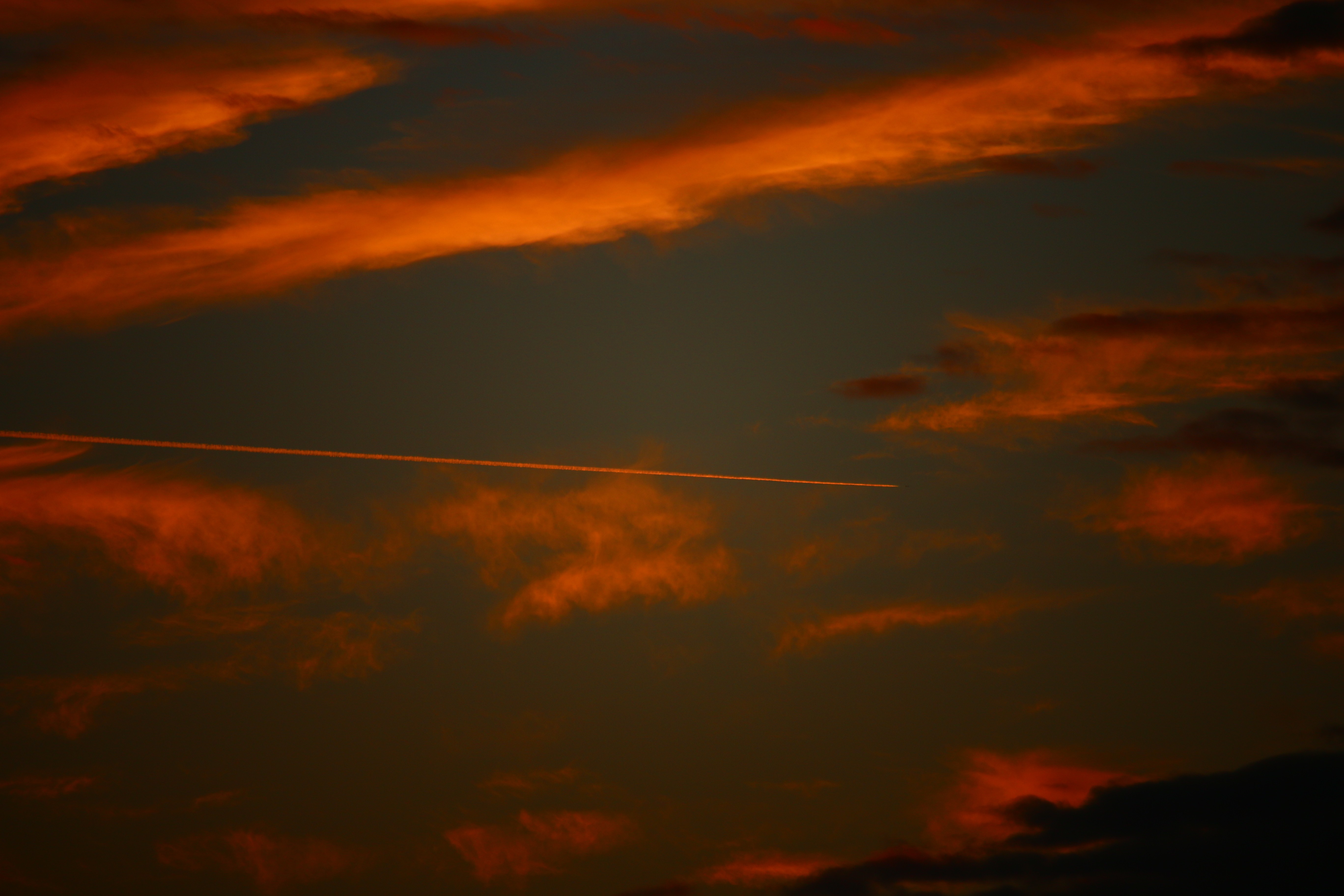 Airplane contrail through sunset clouds HD Wallpaper