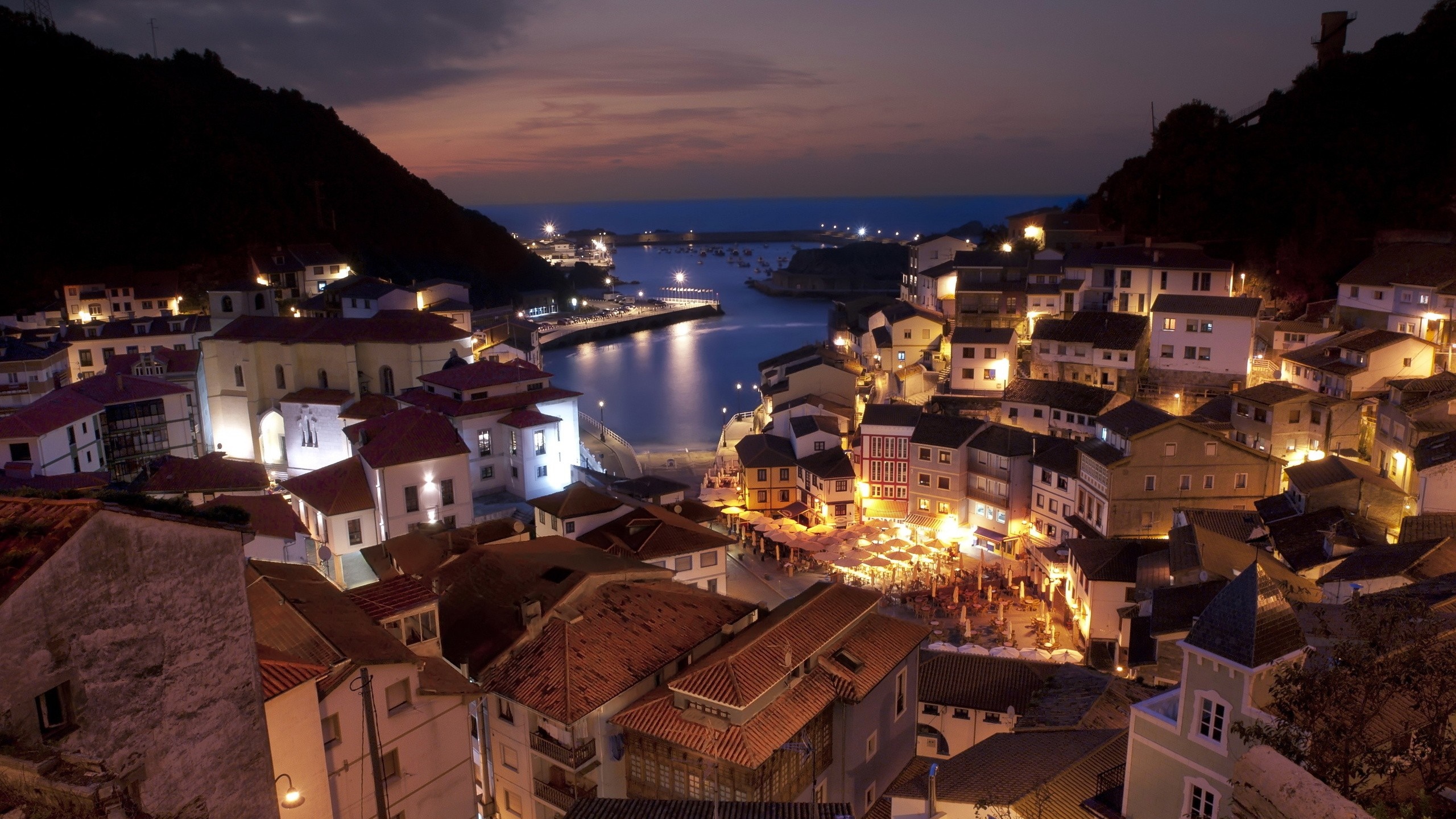 Cudillero, Spain: Coastal town at night with illuminated buildings and bay HD Wallpaper