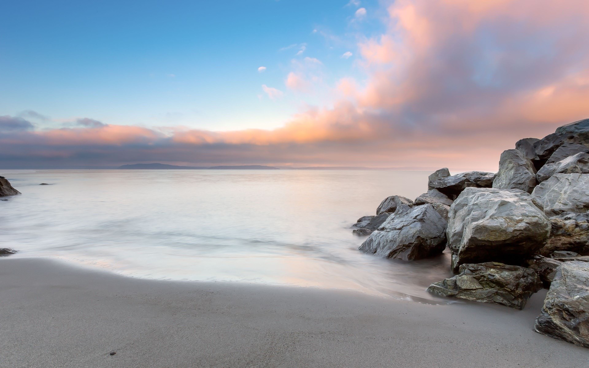 Ocean waves crash on a rocky beach at sunset HD Wallpaper
