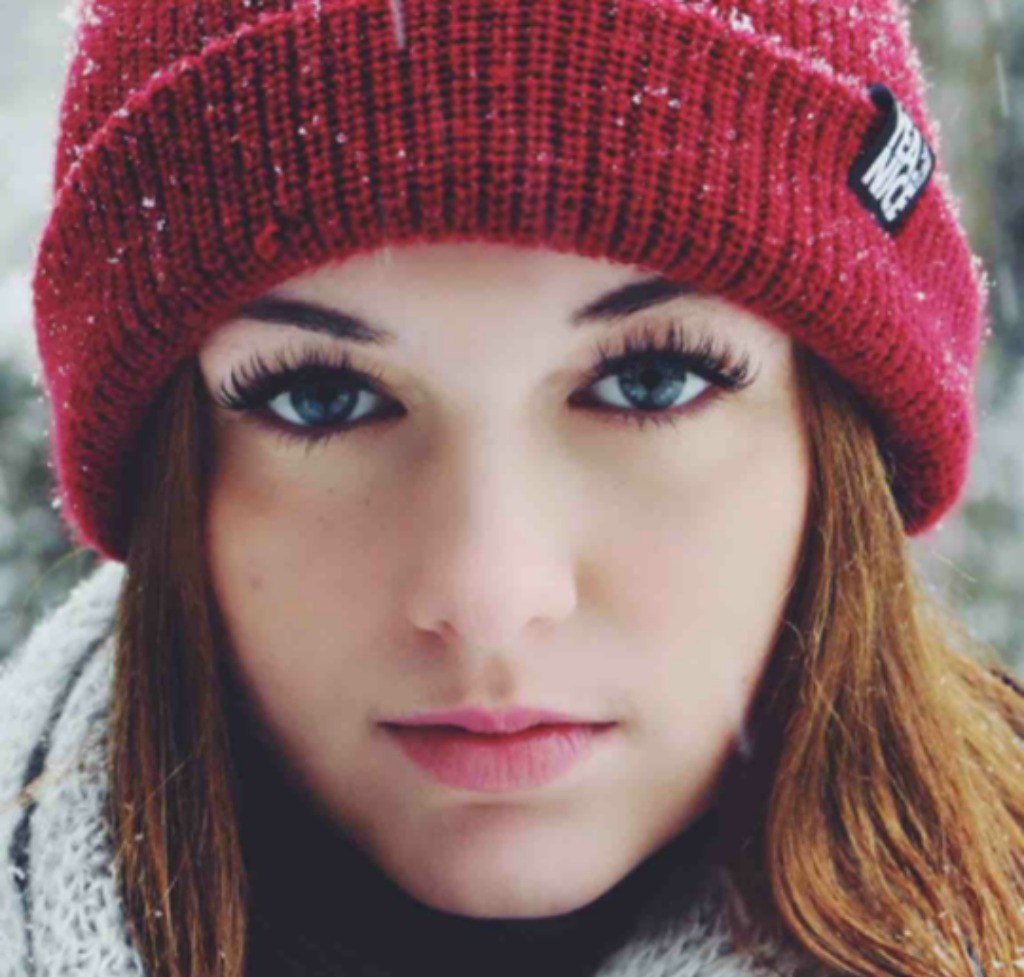 Woman wearing a red beanie in the snow HD Wallpaper