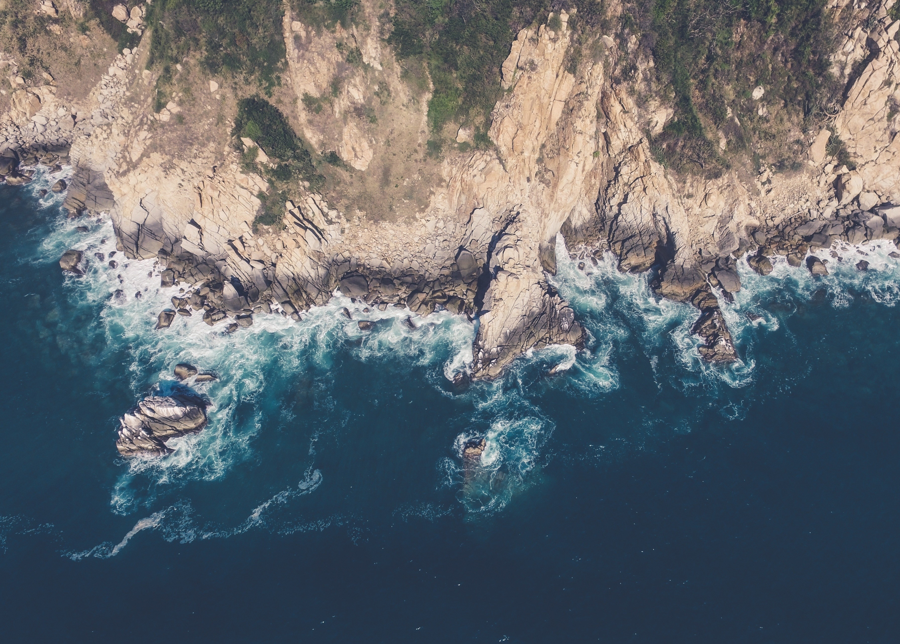 Aerial view of rocky coastline and ocean waves HD Wallpaper