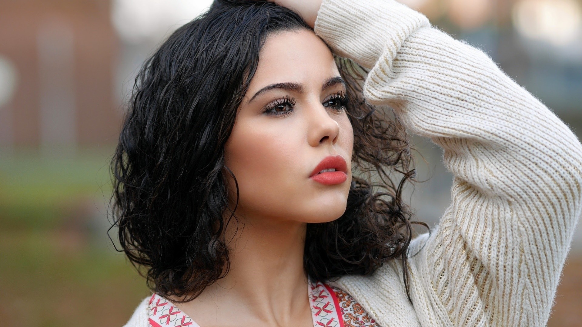 Woman with dark curly hair wearing a cream sweater HD Wallpaper