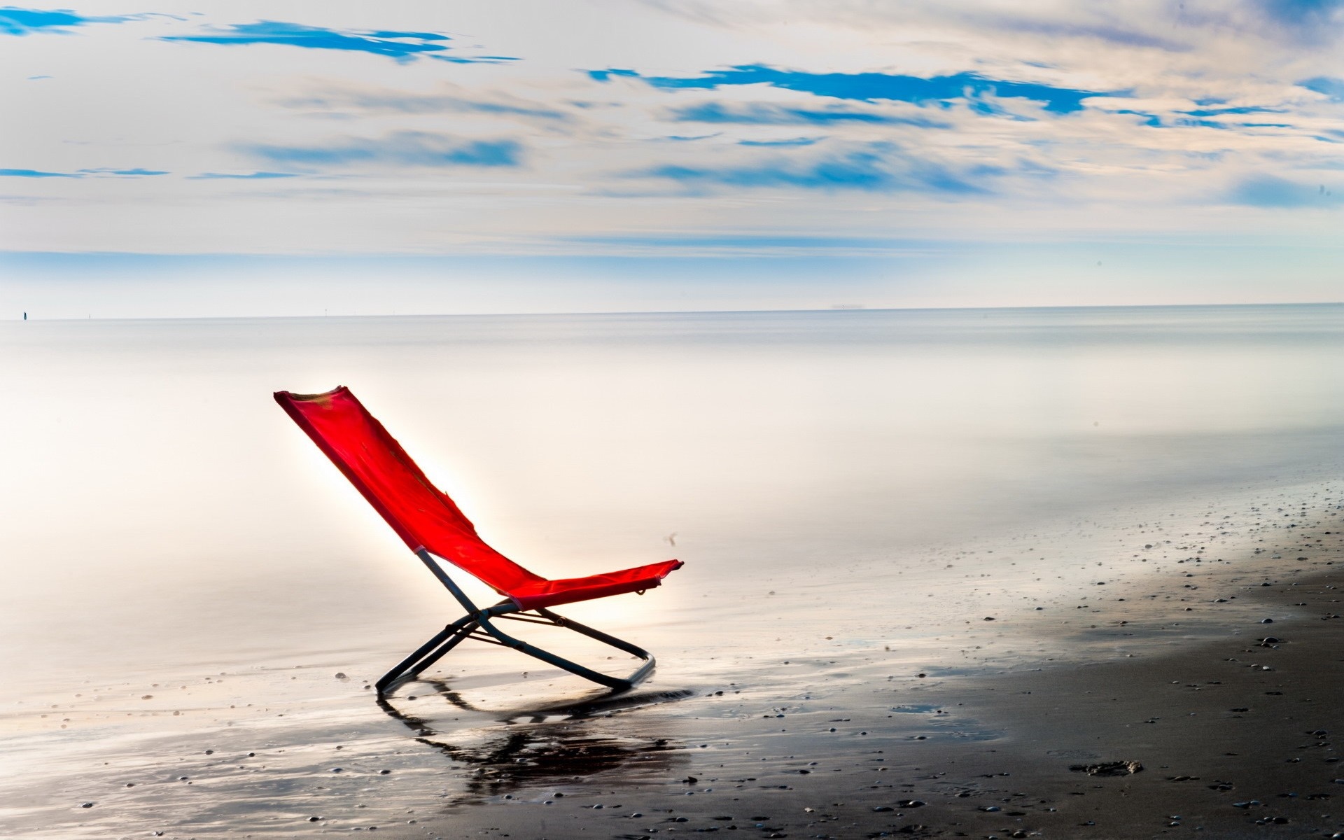 Red chair on a beach with ocean and clouds HD Wallpaper
