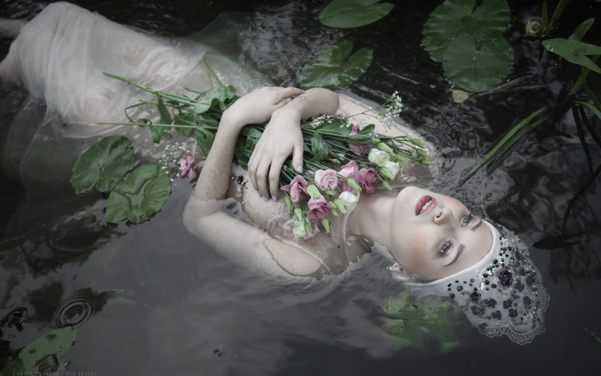 Woman in white dress floating with flowers in water HD Wallpaper