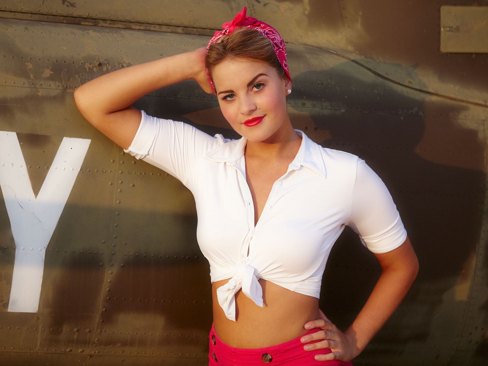 Woman in white shirt and pink skirt posing against a wall HD Wallpaper