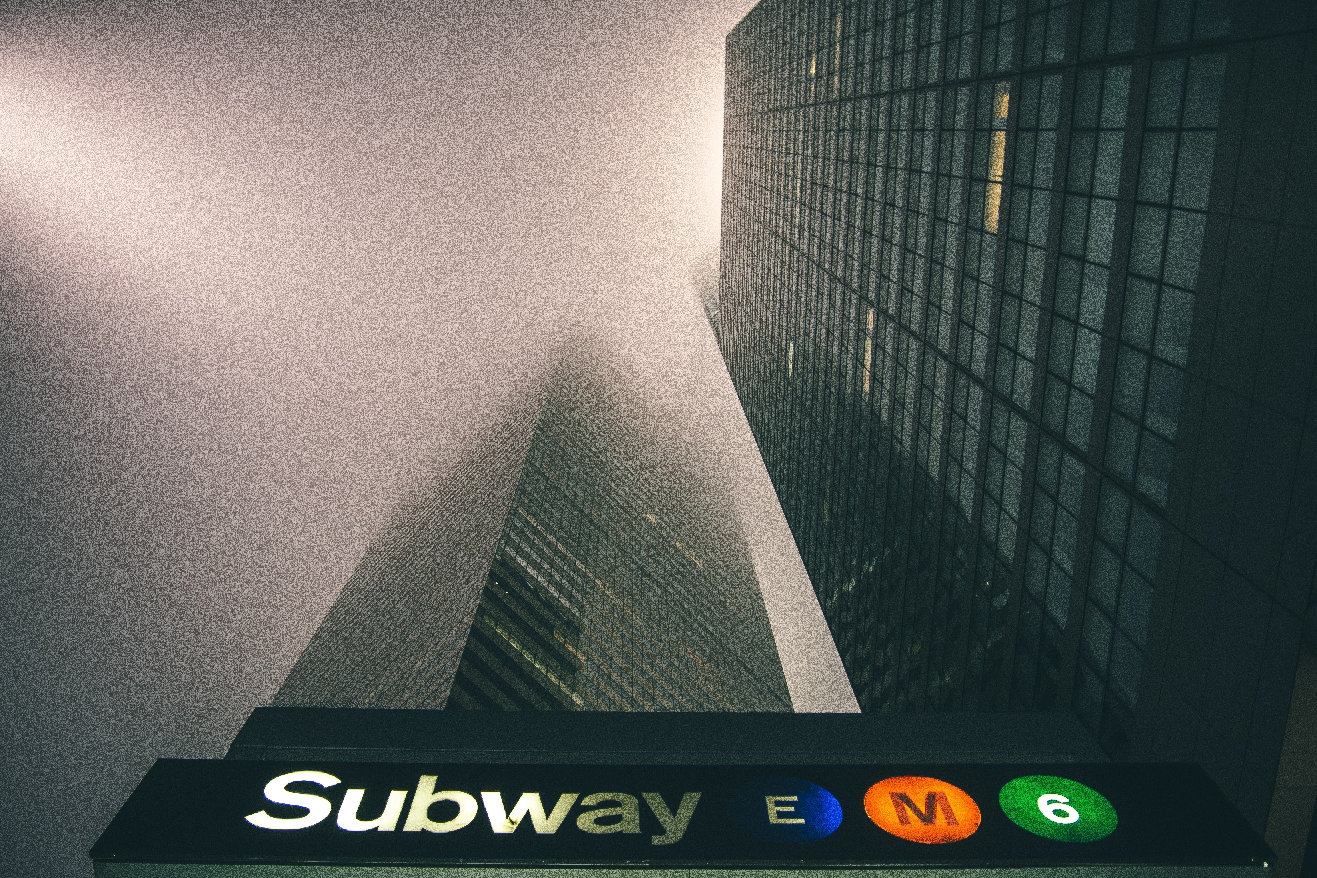 New York City Subway entrance with skyscrapers in fog HD Wallpaper