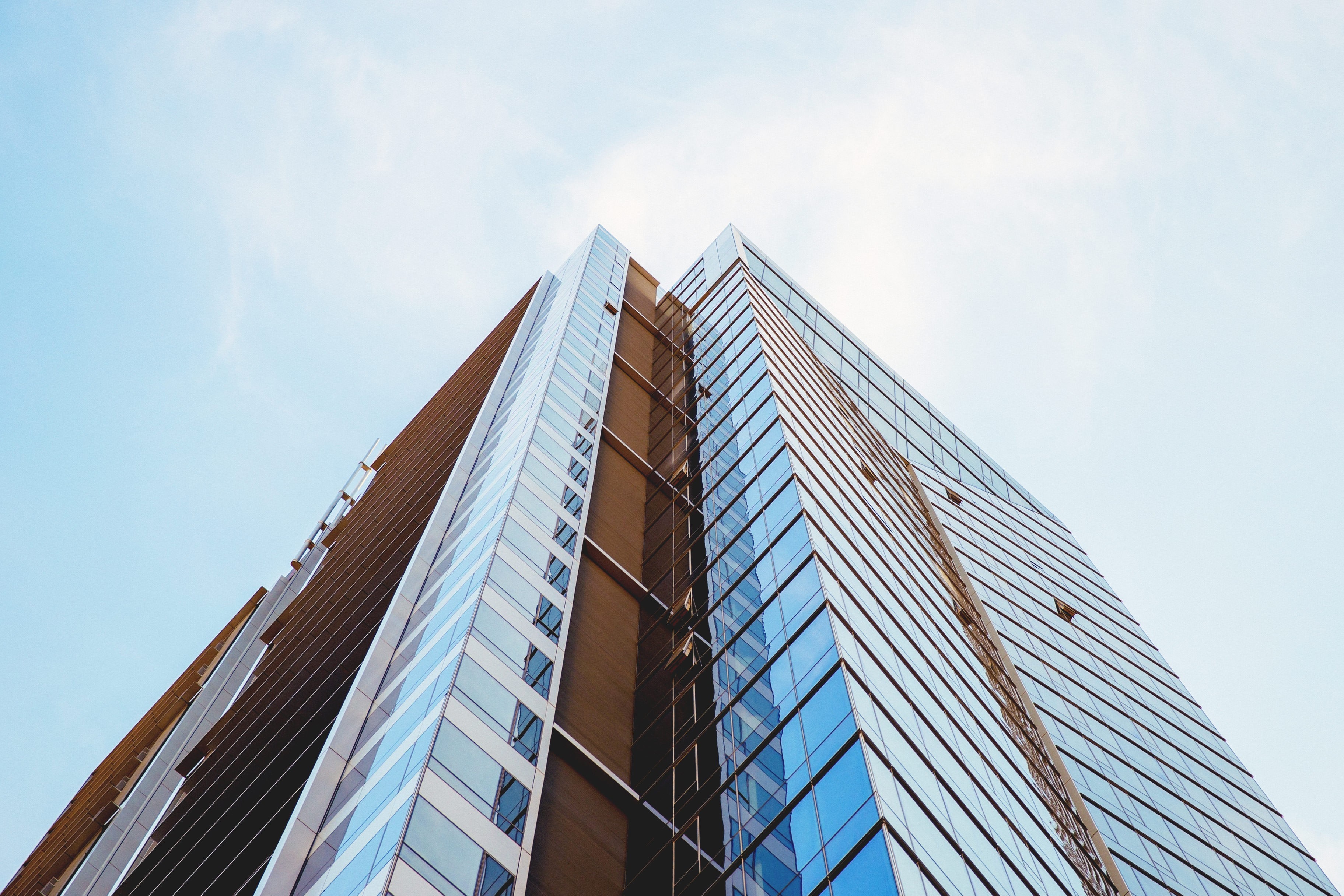Modern glass skyscraper against a clear blue sky HD Wallpaper
