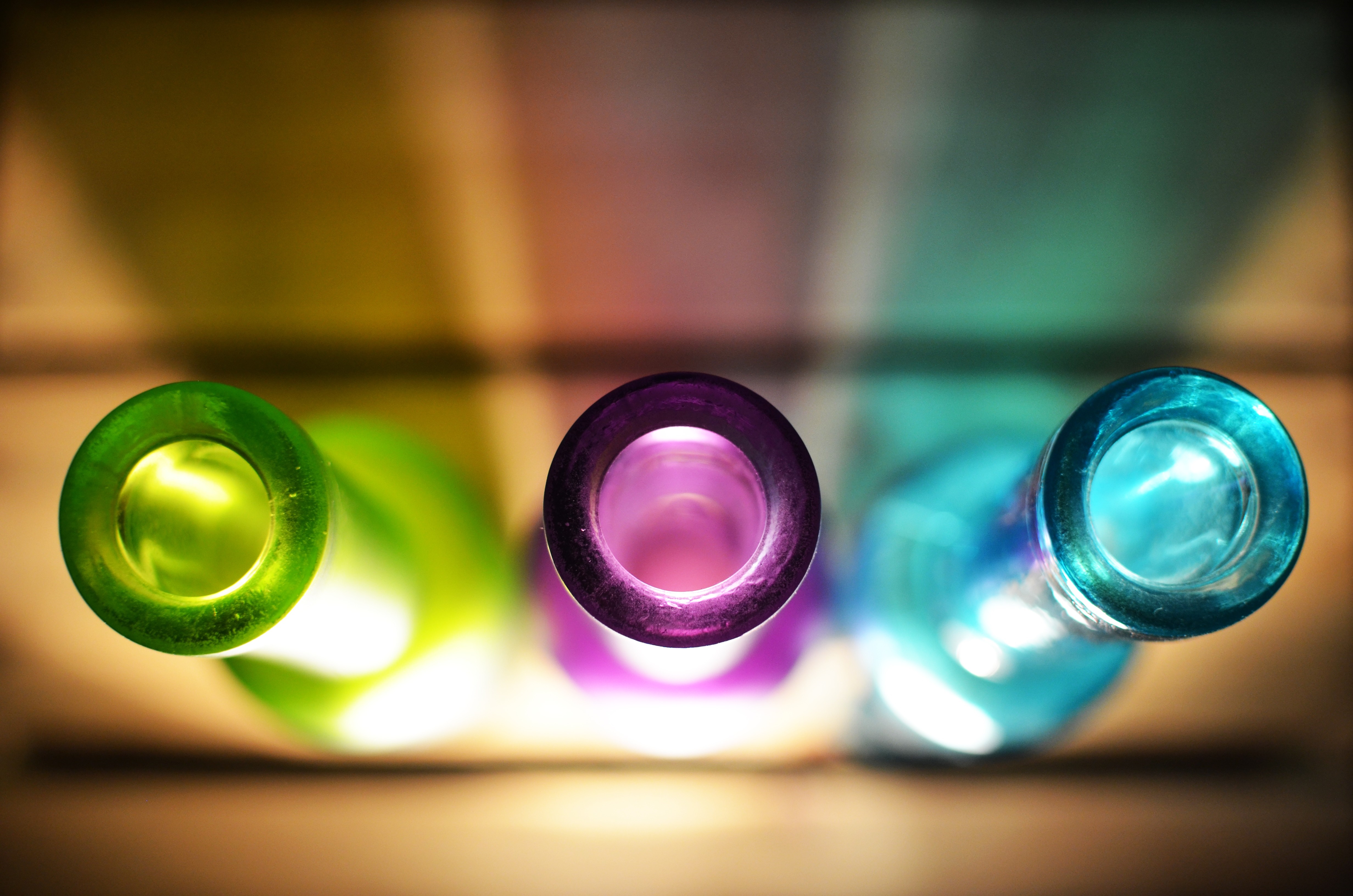 Top view of colorful glass bottles with light effects HD Wallpaper