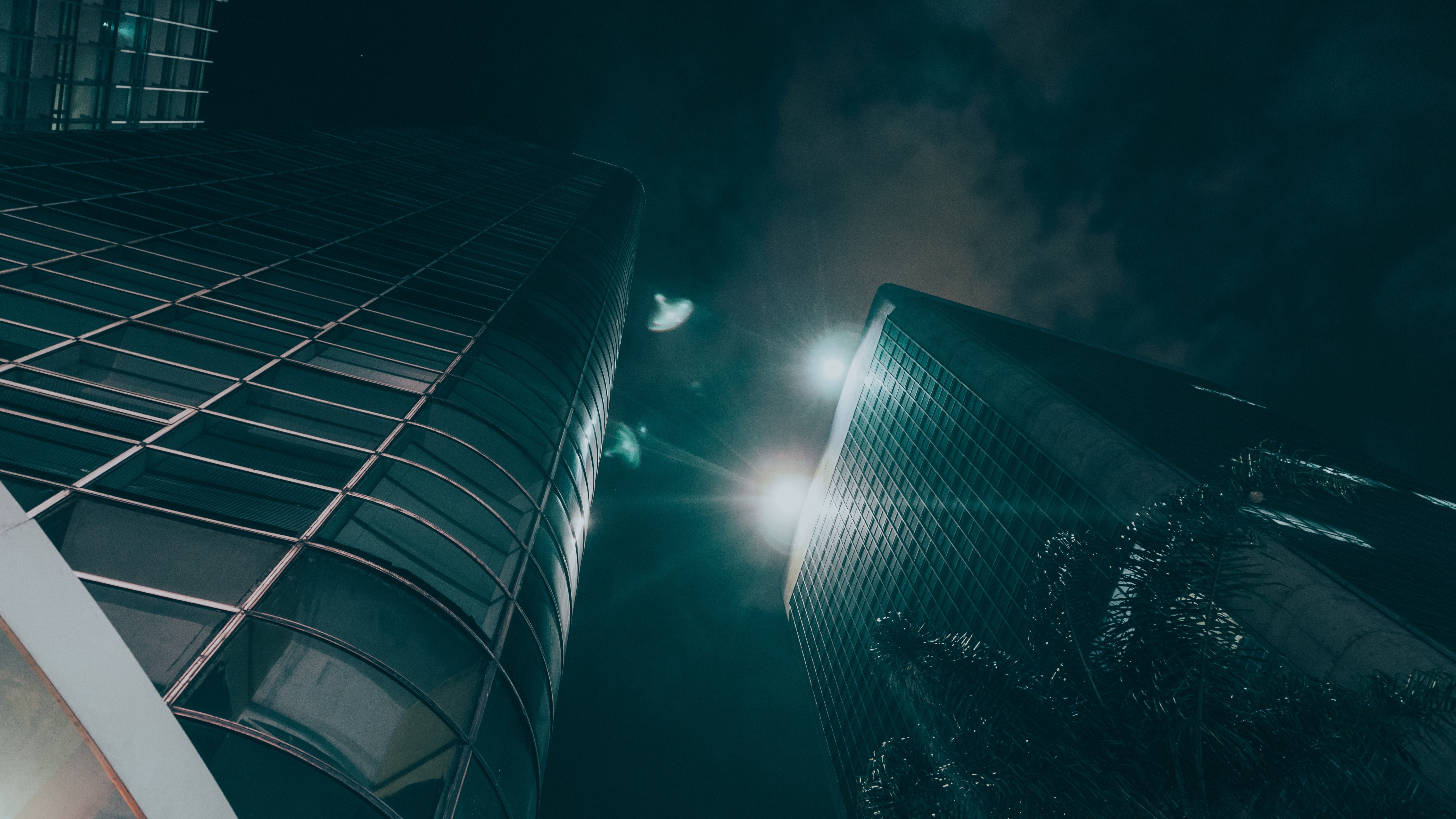 Two skyscrapers at night with bright lights HD Wallpaper
