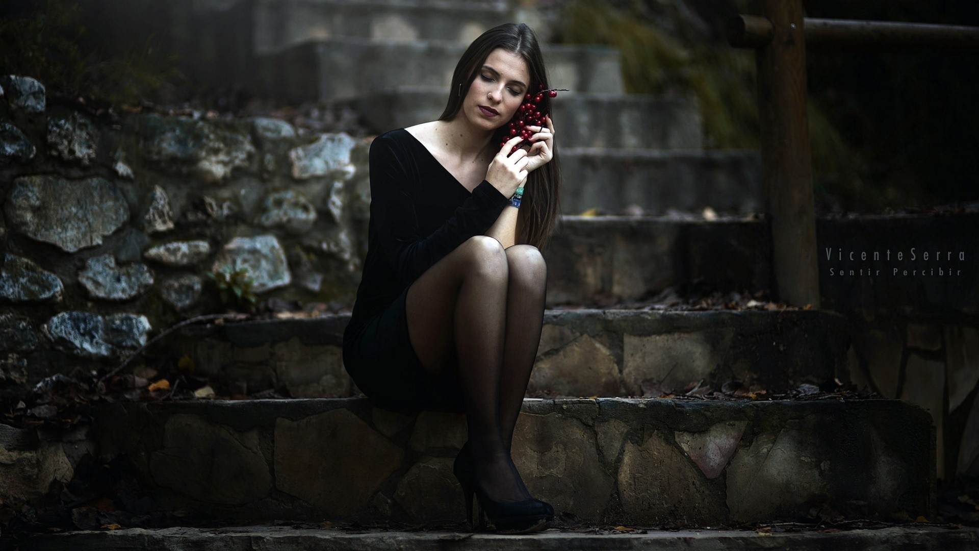 Woman in black dress holding berries on stone stairs HD Wallpaper