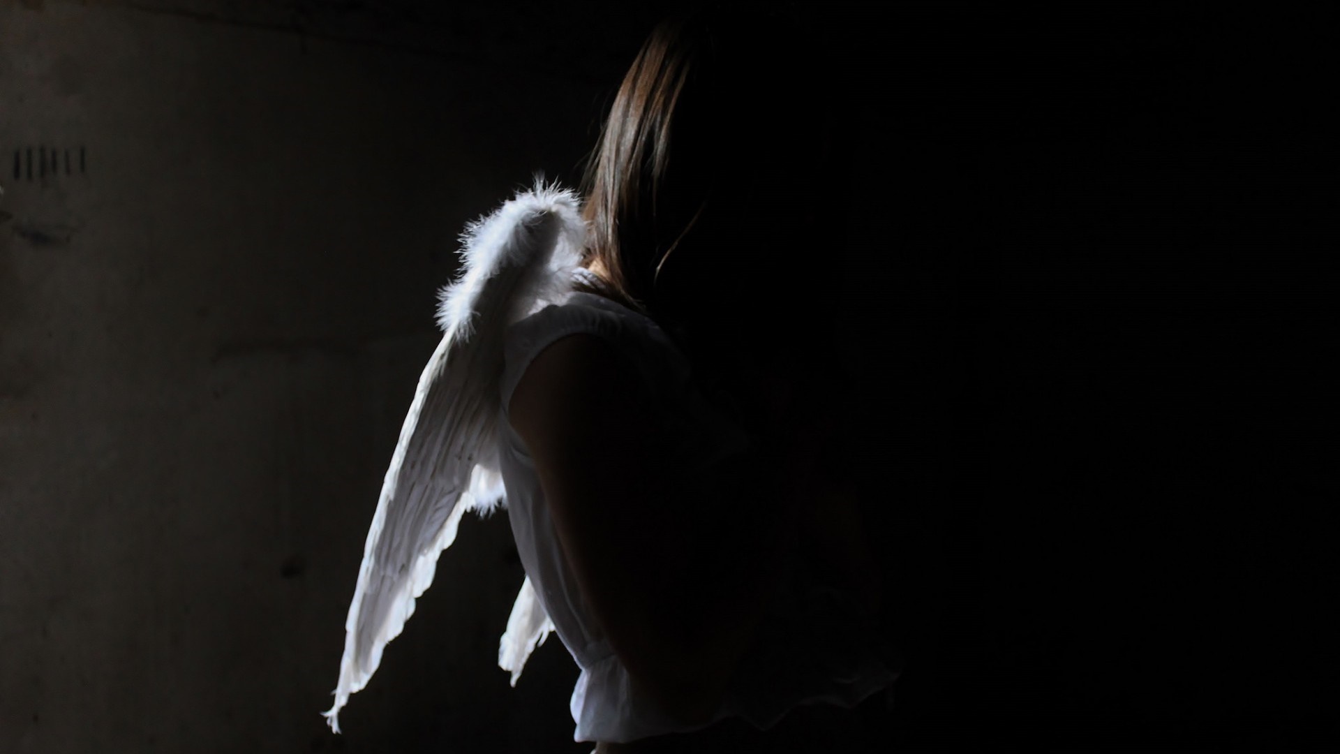 Woman with angel wings in darkness HD Wallpaper
