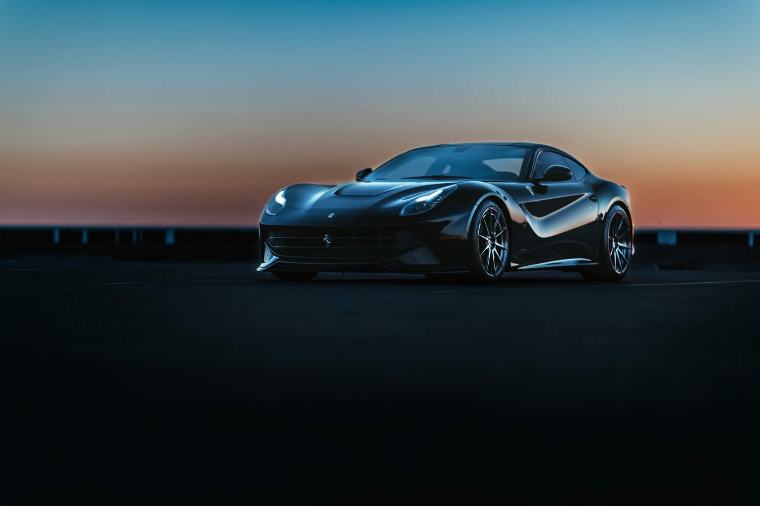 Black Ferrari sports car on a road at sunset HD Wallpaper